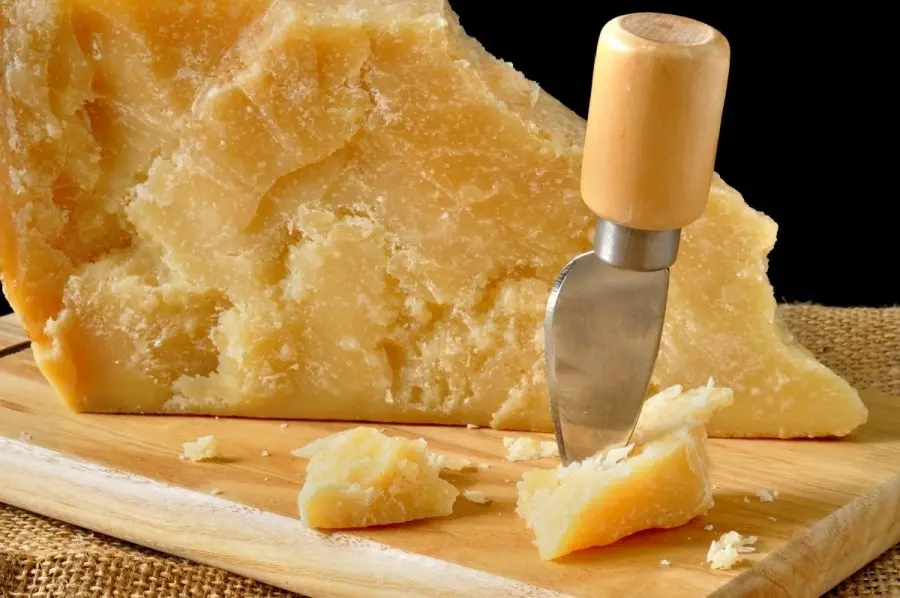 پنیر پارمزان تکهای روی میز چوبی برای استفاده در آشپزی